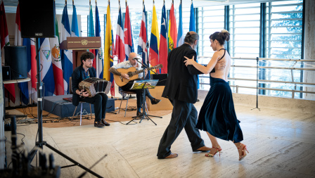 Two tango dancers perform in a brightly lit room at UN Geneva.