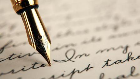 A closeup of a pen, writing on a piece of paper. 