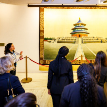 Tour guide Maria giving an explanation about a Chinese tapestry, a gift from a Member State.