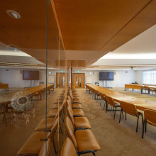 One side of Room is filled with art, the other side gives space to a large, u-shaped meeting table