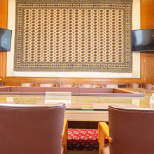 The tapestry behind the table and seats inside Room I