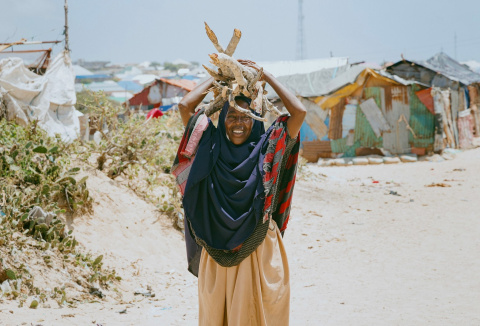 An internally displaced woman carries firewood in the Badbaado II IDP site in Kismayo’s Galbeed district, Somalia. OCHA/Marc Belanger