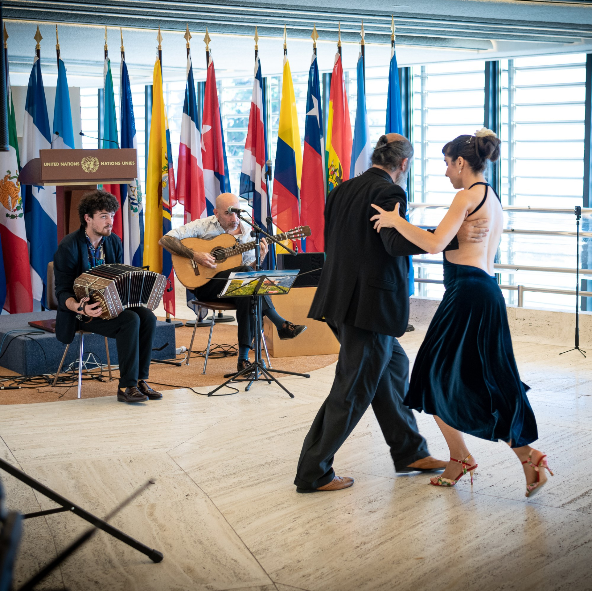Two tango dancers perform in a brightly lit room at UN Geneva.