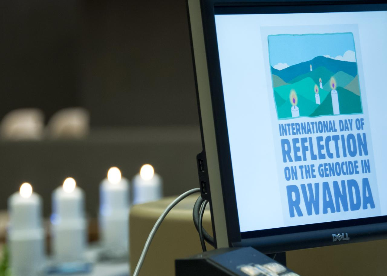 A laptop shows the words "International Day of Reflection on the Genocide in Rwanda". Candles are seen in the background.