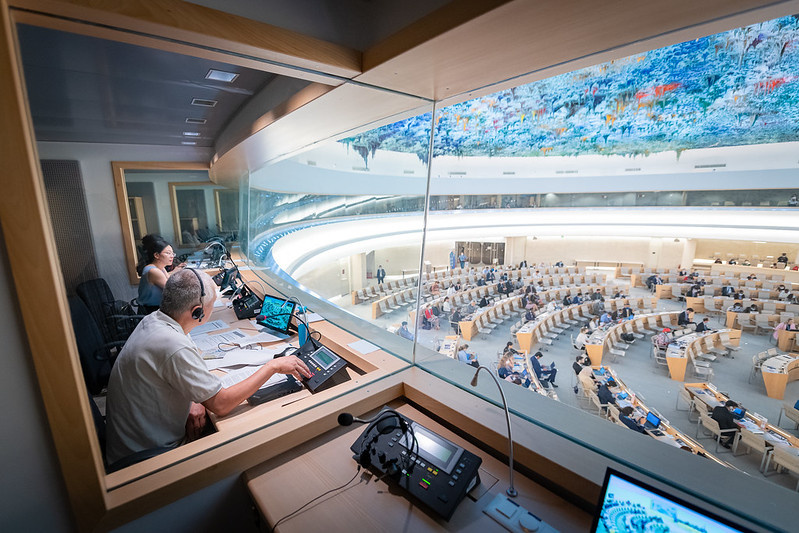 2 interpreters sitting in their cabin overlooking the Human Rights Council chamber