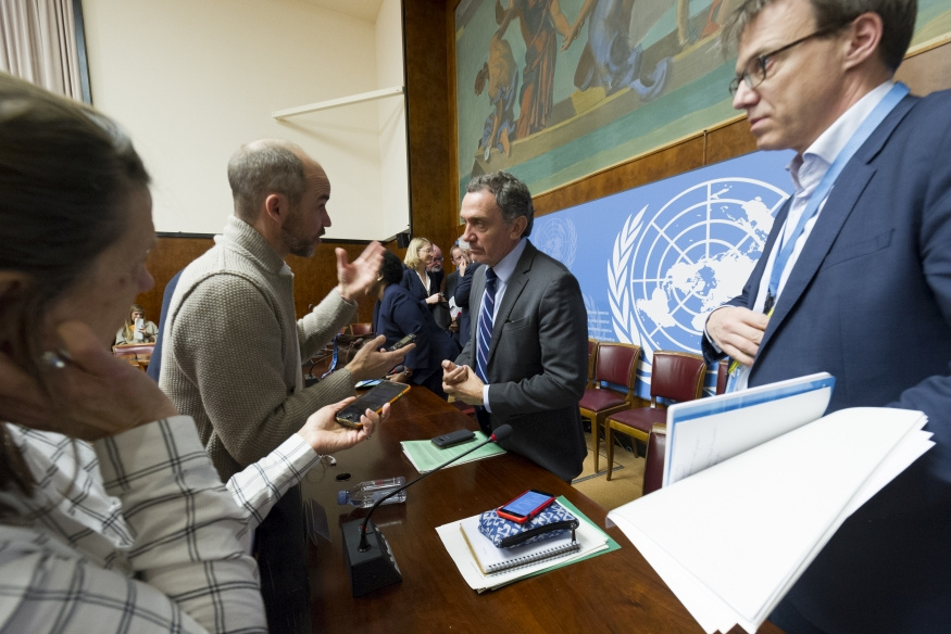 Journalist address UN staff during a press briefing, recording the statements.