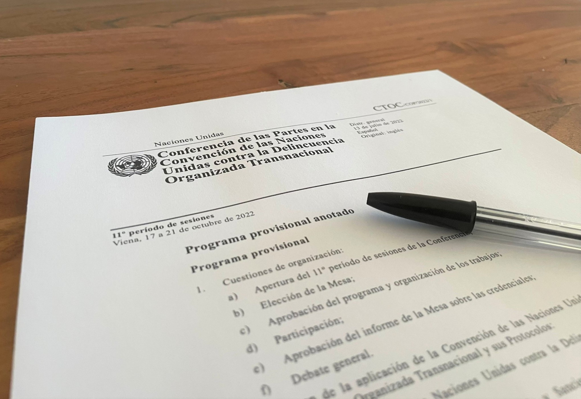 A UN document in Spanish is lying on a table, a pen on top of it.