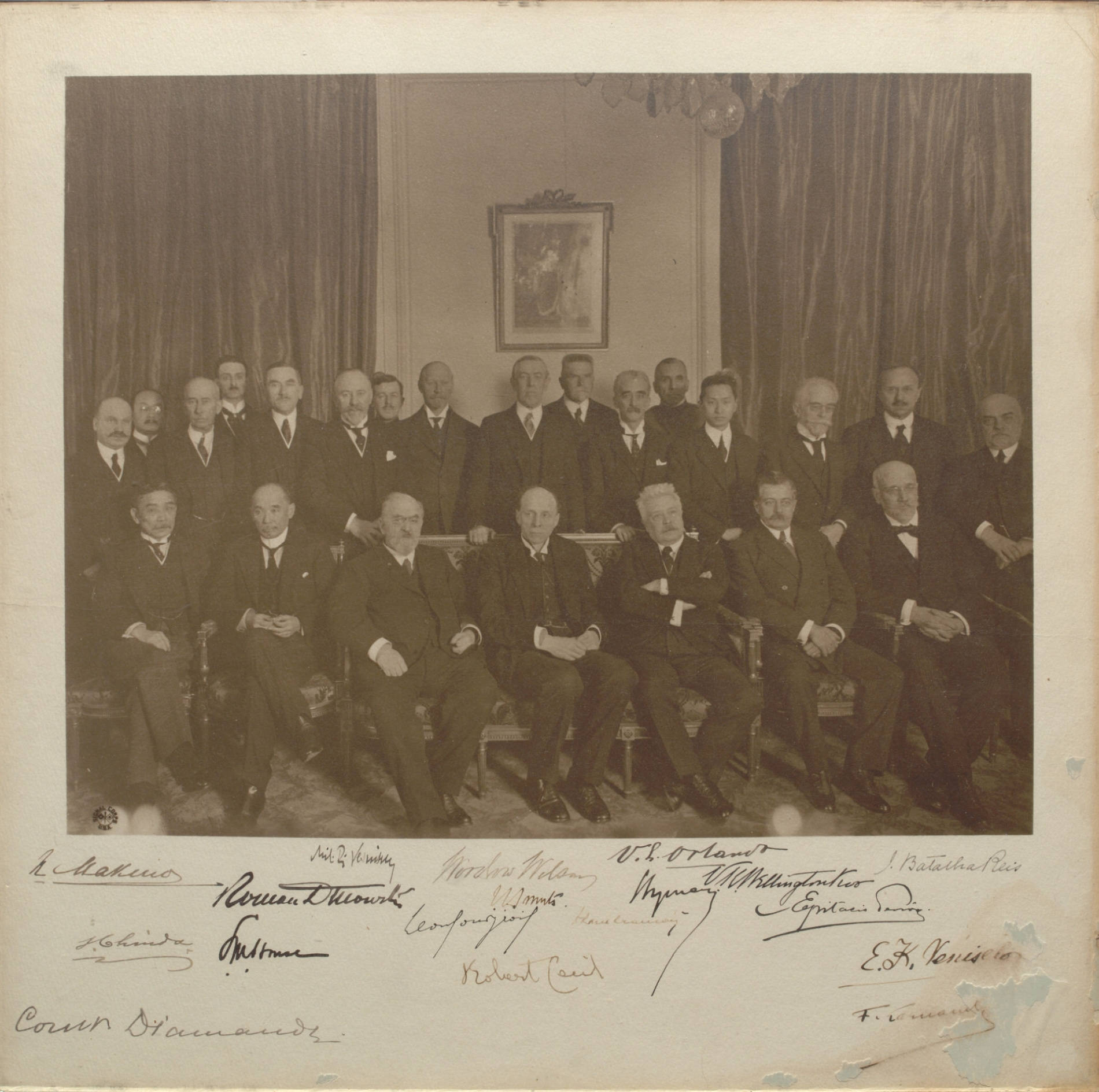 A group of persons sitting inside a room, their signatures are shown below the picture