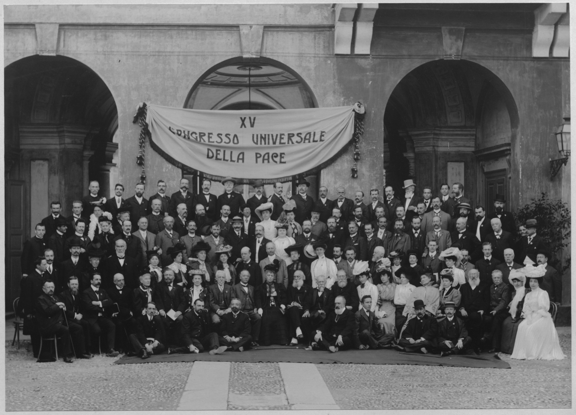 A group photo with around 80 persons. They are holding a banner written "XV Congresso Universale Della Pace"