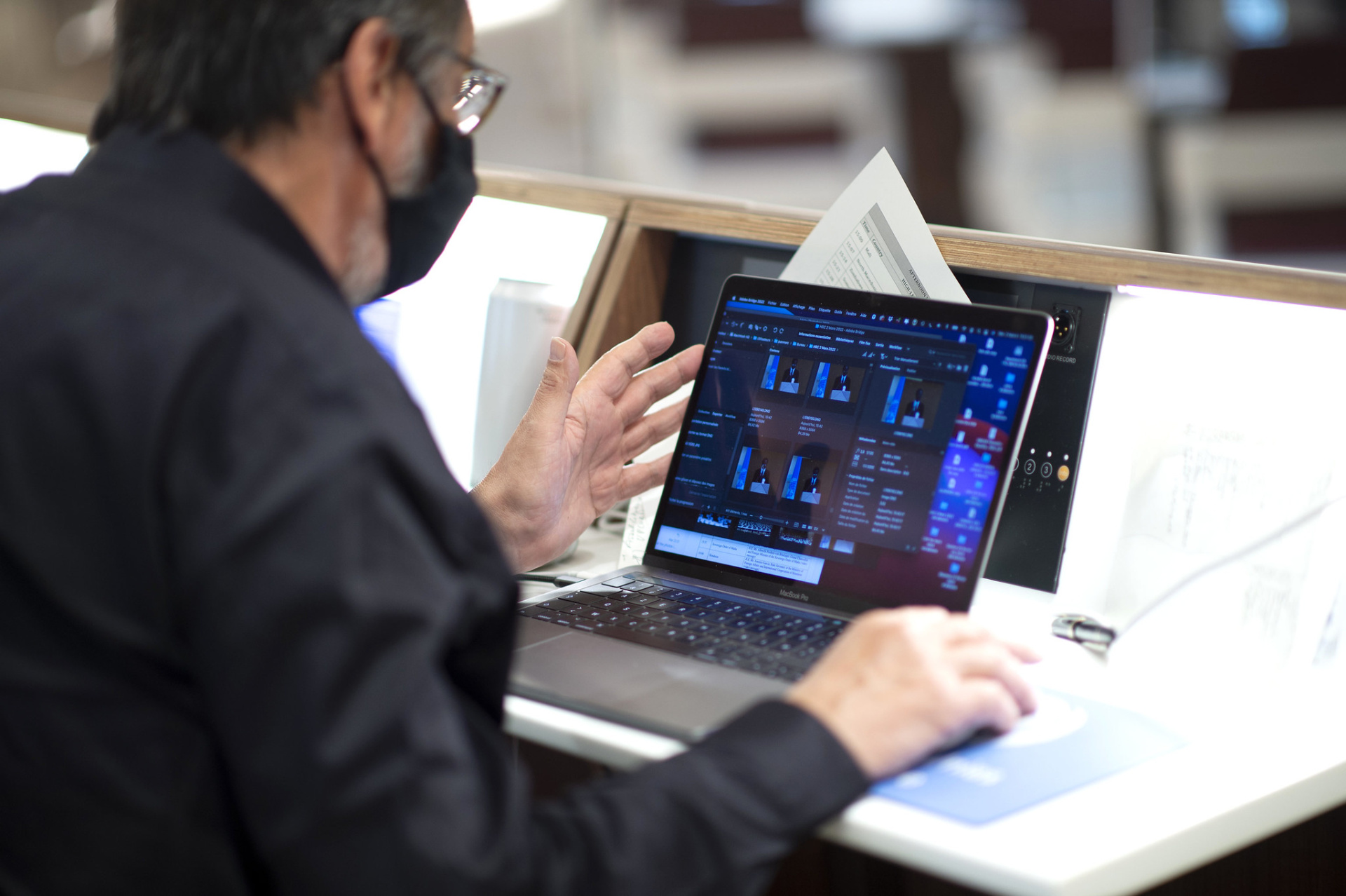 A person sitting at a laptop, testing the audio-visual services