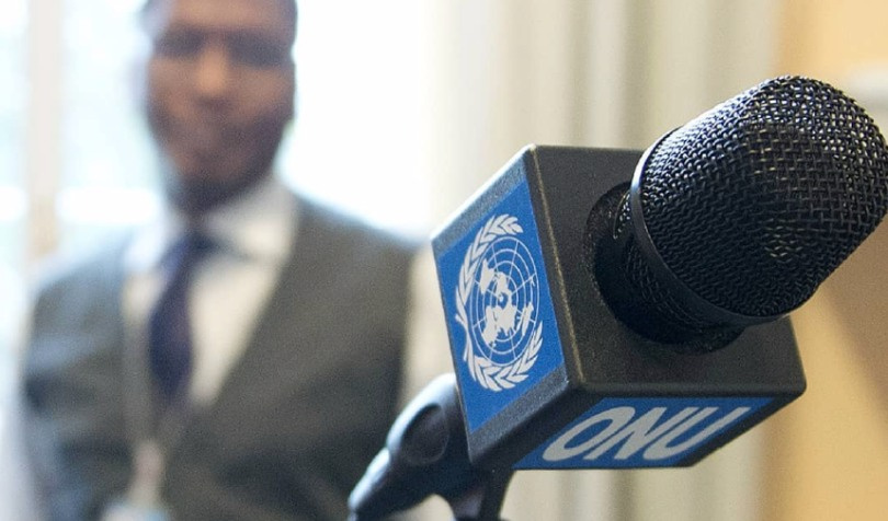 Man holding a microphone with UN logo