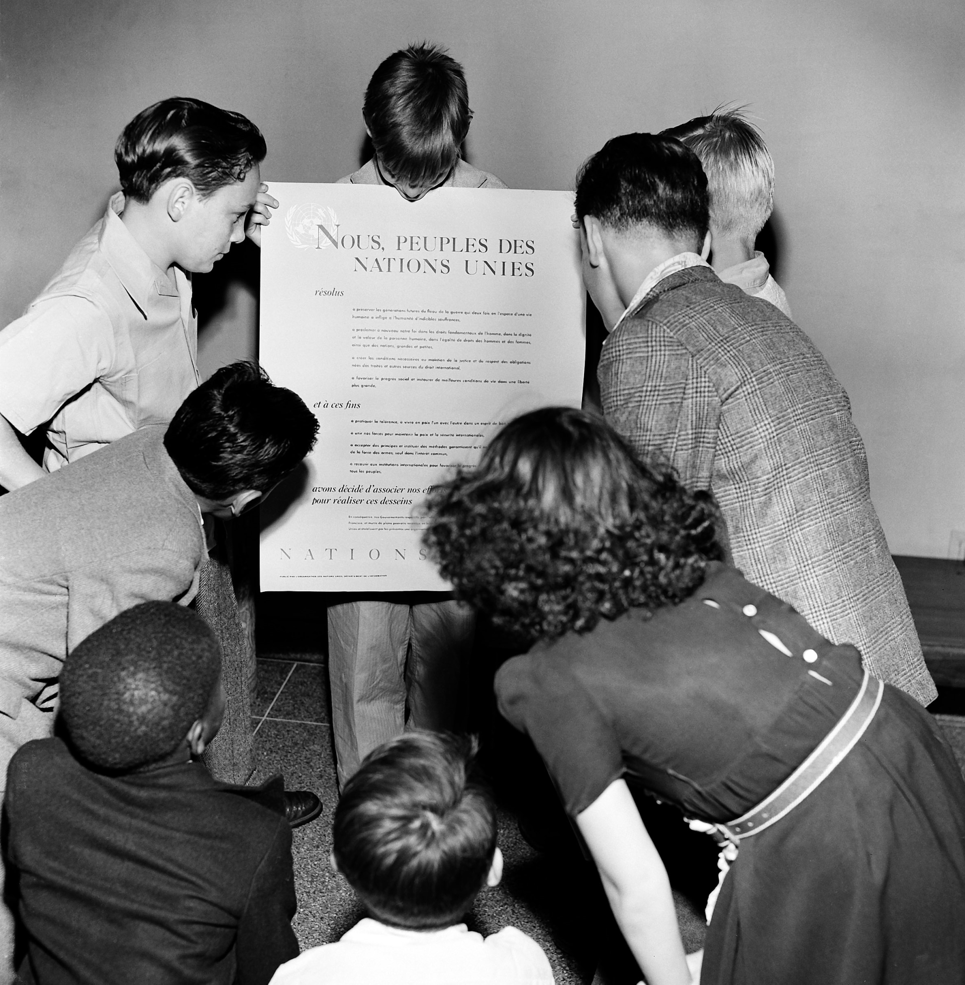 Children are showing the French version of the UN Charter 