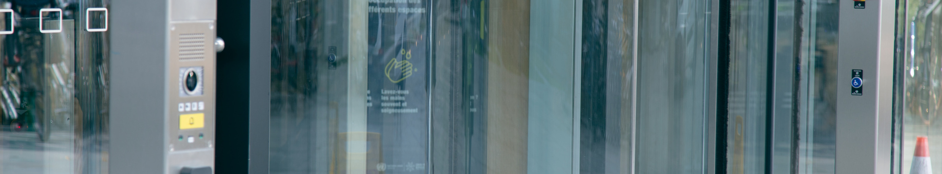 photo of the entrance to Building H at Palais des Nations, with a button to open the wheelchair-accessible door in the foreground