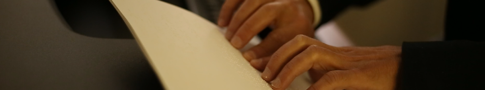 closeup of a pair of hands reading a braille document