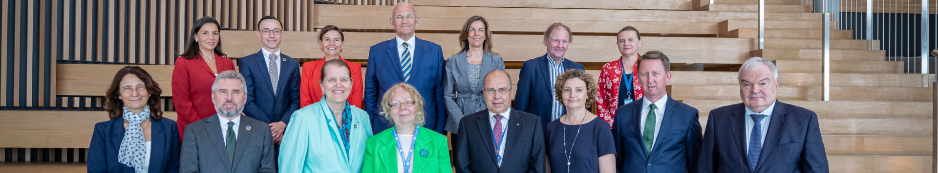 A group photo of the Senior Management Team of UNOG in front of stairs.