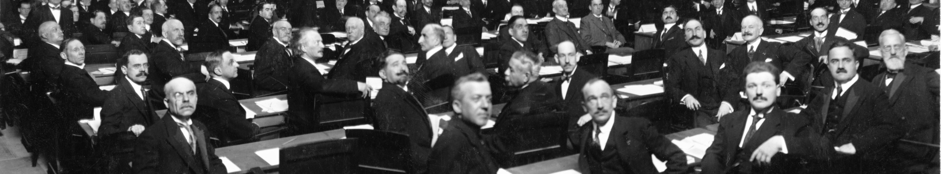 Delegates of the first Assembly turn around on their seats and look towards the back of the room.