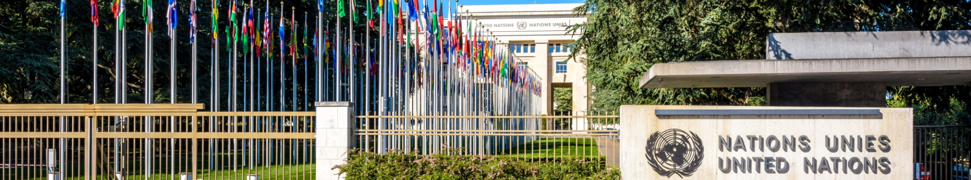 The Palais des Nations from outside, with a view on the Nations Gate, the alley of flags and one of the old buildings.